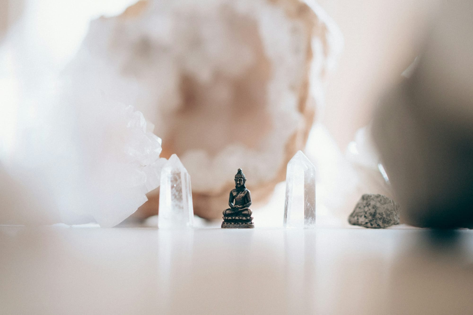 A Buddha statue with some displayed crystals.