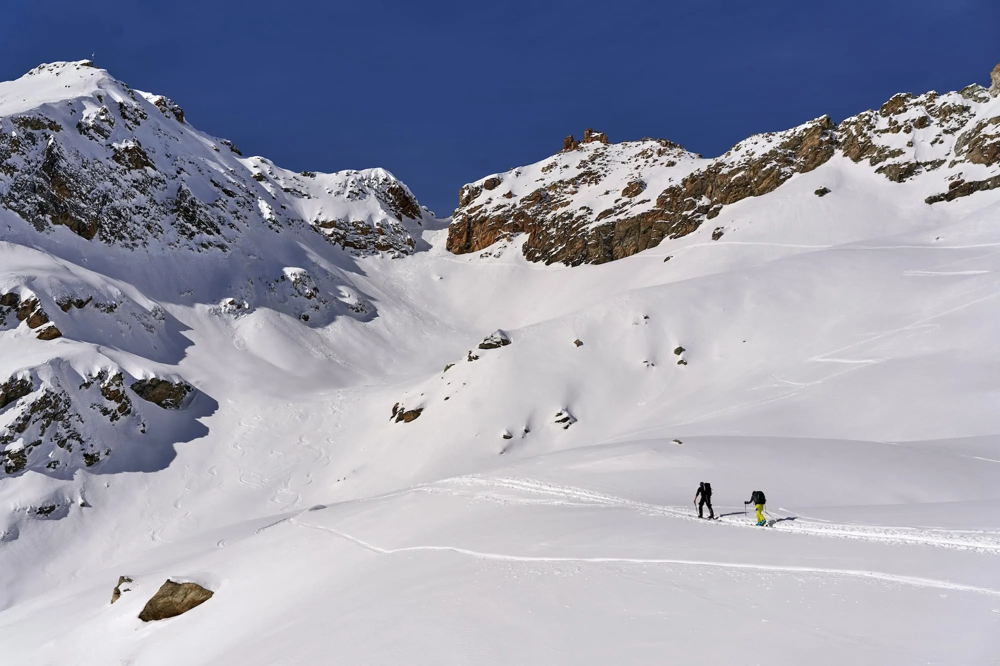 People climbing a snow covered mountain.